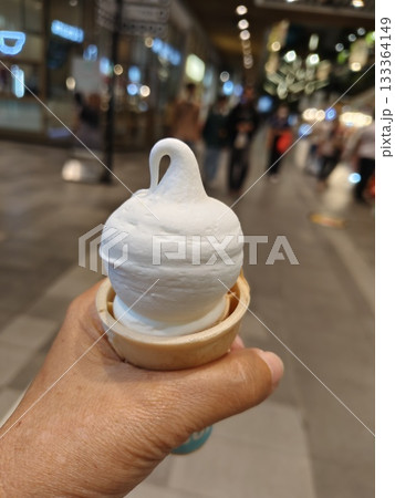 Ice cream cone in left hand. Ice cream cone in left hand. 133364149