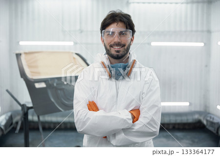 Portrait of an auto body technician in protective gear in a spray booth Portrait of an auto body technician in protective gear in a spray booth 133364177