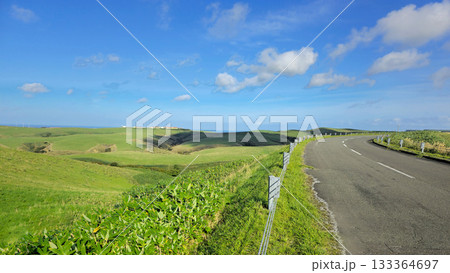A beautiful landscape showcases a winding road, perfect for travel and adventure, with rolling hills and a vibrant sky A beautiful landscape showcases a winding road, perfect for travel and adventure, with rolling hills and a vibrant sky 133364697