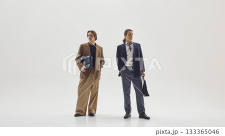 Two stylish male professionals posing confidently in modern tailored office outfits Two stylish male professionals posing confidently in modern tailored office outfits 133365046