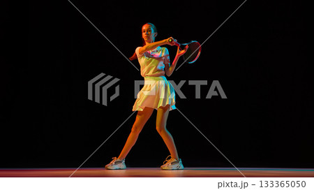 Female tennis player hitting forehand with strength and focus Female tennis player hitting forehand with strength and focus 133365050