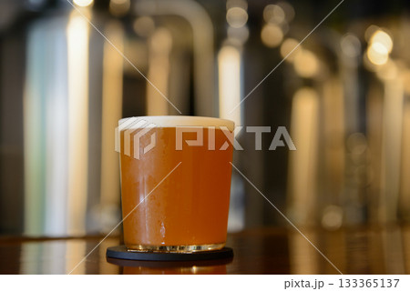 タップルームのカウンターに置かれたエールスタイルのクラフトビール 133365137