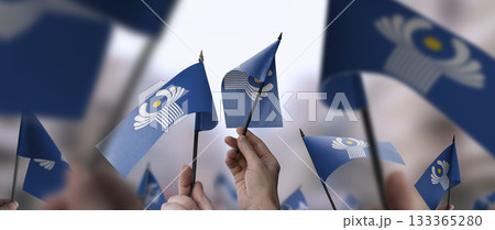 CIS flags in their hands on a blurred urban background 133365280