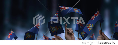 Cayman Islands flags in their hands on a blurred urban background 133365315