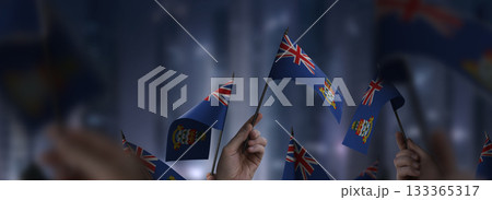 Cayman Islands flags in their hands on a blurred urban background 133365317