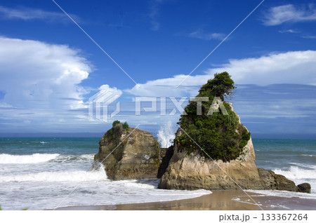 夏の茨城県、日立市の海岸。大きな岩に打ち寄せる白い波と積乱雲が青空に印象的で綺麗だ。 133367264
