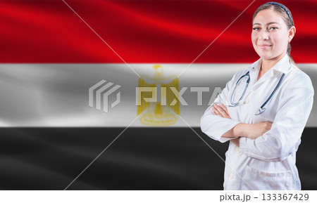Female doctor on Egypt flag. Doctor with crossed arms on Egypt flag. Egypt health and care concept Female doctor on Egypt flag. Doctor with crossed arms on Egypt flag. Egypt health and care concept 133367429