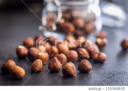 Peeled hazelnut kernels on black table. 133368638