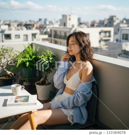 マンションのベランダで椅子に座り薄着でくつろぐ若い日本人女性 133369076