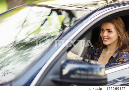 Happy woman driver at car smiling. Cute young happy brunette female driving car vehicle Happy woman driver at car smiling. Cute young happy brunette female driving car vehicle 133369175