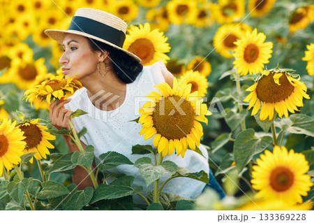 Beautiful young woman in a hat on a field of sunflowers Beautiful young woman in a hat on a field of sunflowers 133369228