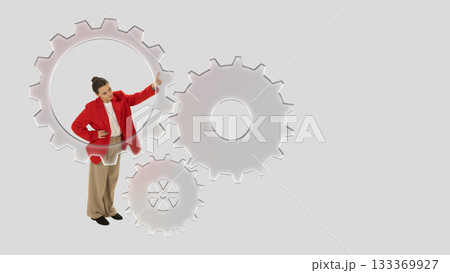 Creative composition. Businesswoman inside gear mechanism adjusting system with confident emotion 133369927