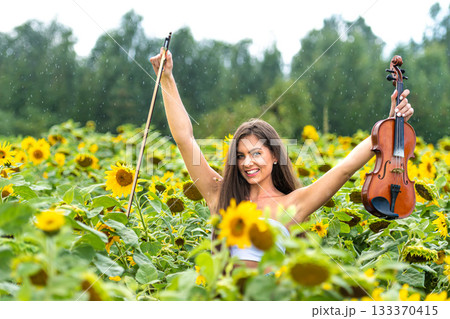 beautiful slim teenager woman with violin in yellow blooming sunflower field in rainy day beautiful slim teenager woman with violin in yellow blooming sunflower field in rainy day 133370415