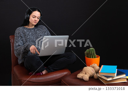 focused young freelance woman sitting with laptop and headphones, have business meeting via video call focused young freelance woman sitting with laptop and headphones, have business meeting via video call 133371018