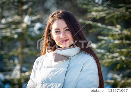 cheerful lady in winter clothes posing with joy outside in the snow forest 133371067