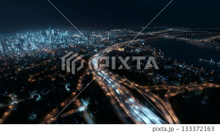Skyline view of a bustling city at night with bright lights and highways 133372163