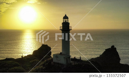 石垣島の夕陽と光る海と灯台のシルエットの空撮 石垣島の夕陽と光る海と灯台のシルエットの空撮 133372507