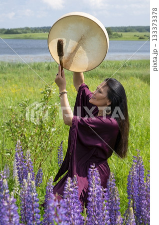 Female shaman drumming among the flowers Female shaman drumming among the flowers 133373378