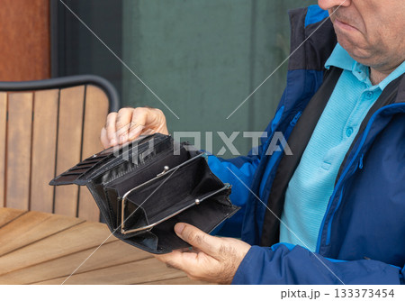 Empty wallet in hands close-up. A black wallet with no money, poor person, economy crisis Empty wallet in hands close-up. A black wallet with no money, poor person, economy crisis 133373454