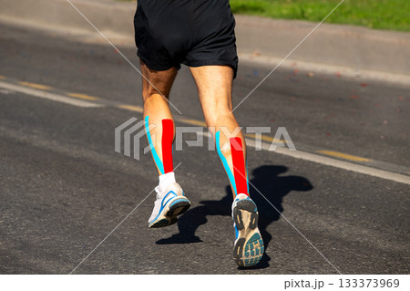 Kinesiotaping on runner calf muscle to running marathon race Kinesiotaping on runner calf muscle to running marathon race 133373969
