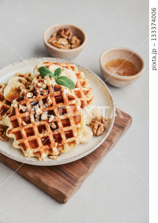 Homemade waffles with topping of honey, walnut and banana Homemade waffles with topping of honey, walnut and banana 133374006