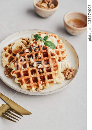 Homemade waffles with topping of honey, walnut and banana Homemade waffles with topping of honey, walnut and banana 133374008