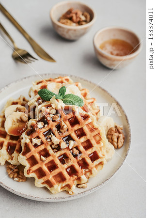 Homemade waffles with topping of honey, walnut and banana Homemade waffles with topping of honey, walnut and banana 133374011
