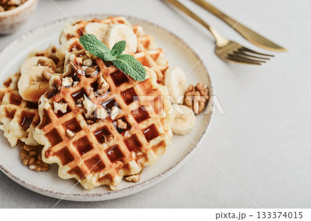 Homemade waffles with topping of honey, walnut and banana 133374015
