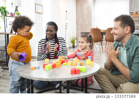 Multiracial family playtime with colorful blocks in a cozy living room Multiracial family playtime with colorful blocks in a cozy living room 133377169