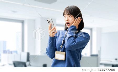 スマートフォンの画面を見て驚く女性・ビジネスウーマン スマートフォンの画面を見て驚く女性・ビジネスウーマン 133377206