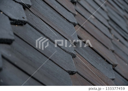 shingles on the roof. Wooden roof, shingled roof. Wooden tile. Roof of complex construction with dormer windows shingles on the roof. Wooden roof, shingled roof. Wooden tile. Roof of complex construction with dormer windows 133377459
