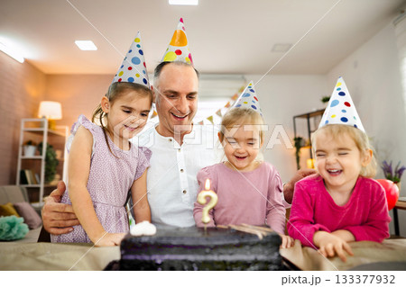 Celebrating a joyful birthday with family in a cheerful home setting Celebrating a joyful birthday with family in a cheerful home setting 133377932