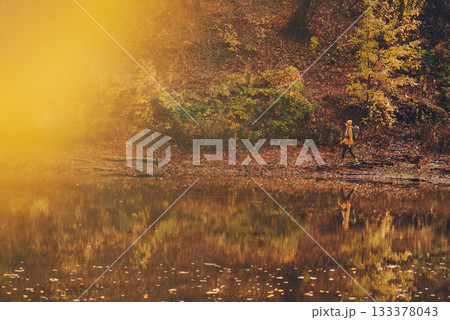 Woman Hiking Alone Autumn Forest lake 133378043