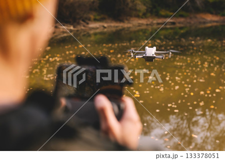 Person Using Remote Control to Fly Drone Person Using Remote Control to Fly Drone 133378051