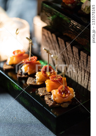 Pumpernickel bread sandwich snack with cured smoked salmon and fresh avocado served as close-up on a wooden cutting board 133378165