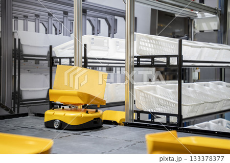 Automatic warehouse robot car carries cardboard box assembly in factory. 133378377