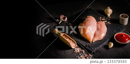 Raw organic chicken breast on a dark slate, stone, concrete or metal background.Top view with copy space. 133378583