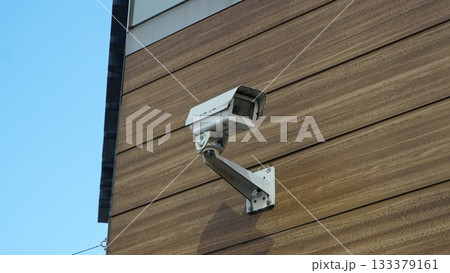 CCTV camera attached to the wooden pattern exterior wall of the building CCTV camera attached to the wooden pattern exterior wall of the building 133379161