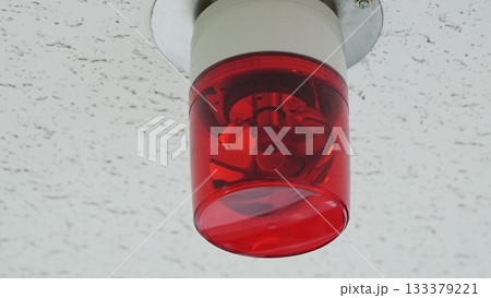Red warning light attached to the ceiling 133379221