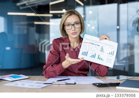 Businesswoman presenting quarterly revenue and loss statement dashboard, explaining financial performance and market trends during a corporate meeting in a modern office 133379308