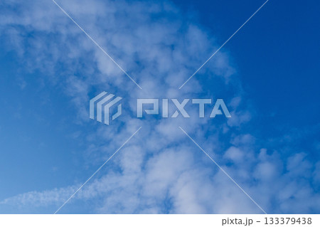 White clouds on blue sky. Bizarrely shaped fluffy cirrocumulus clouds in summer sunny day. Nature cloudscape background. 133379438