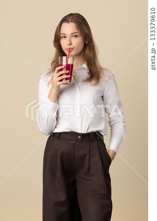 Beautiful woman drinking red juice with straw Beautiful woman drinking red juice with straw 133379610