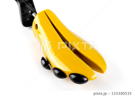 Plastic yellow shoe stretcher with black knobs for adjusting shoe width and shape on white background. Close-up. 133380535