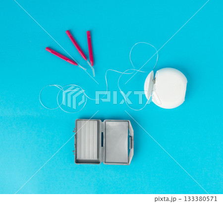 Dental floss, orthodontic wax box and interdental brushes top view. Dental hygiene set 133380571
