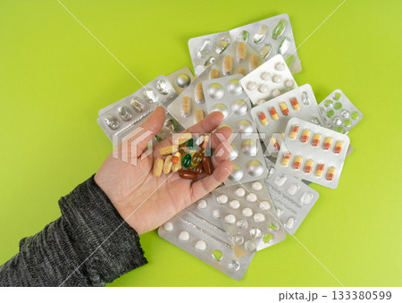 Hand with Color Pill Capsules on Green Background, Overdose Concept, Opioid Problem, Poison, Analgesic Hand with Color Pill Capsules on Green Background, Overdose Concept, Opioid Problem, Poison, Analgesic 133380599