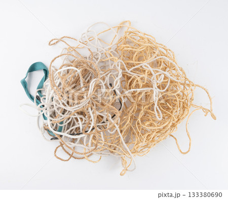 String piece isolated, jute rope fragment, part of packaging cord knots, eco-friendly natural rope 133380690