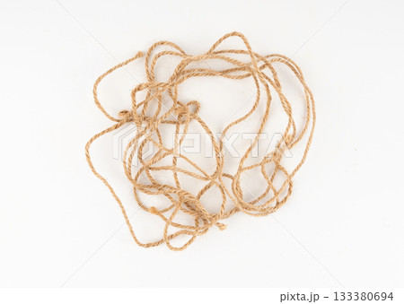Twine rope piece isolated, jute loop fragment, beige packaging cord knots, old natural line cable 133380694