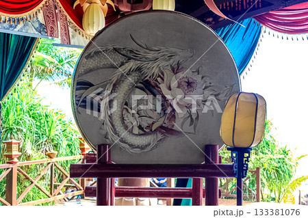 A large decorative drum with a dragon and flowers at the Sky Grottoes Park on Hainan Island, China. 133381076