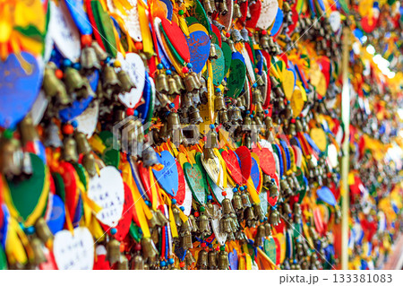 Brightly colored wooden heart-shaped signs with wishes and bells at Nanshan Park, Hainan, China. Brightly colored wooden heart-shaped signs with wishes and bells at Nanshan Park, Hainan, China. 133381083