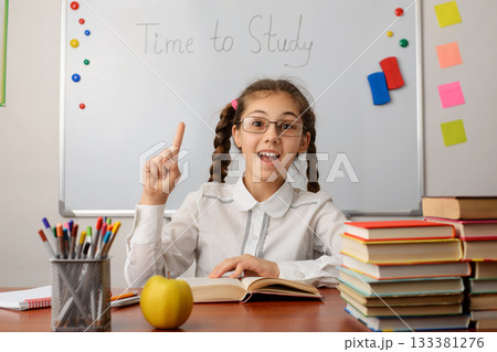 Smart school girl pointing index finger up. Concept of brilliant idea 133381276
